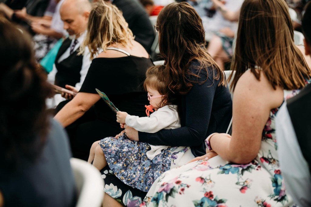 wedding guests seated during ceremony wearing semi formal attire at outdoor wedding